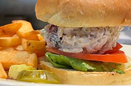 cranberry chicken salad on a bun with golden french fries